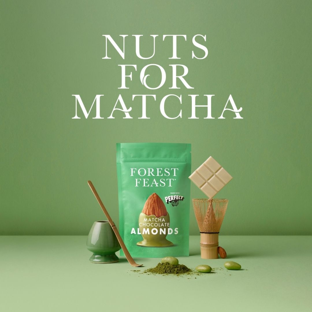 Forest Feast Matcha Chocolate Almonds product pouch displayed with a bamboo tea whisk and white chocolate