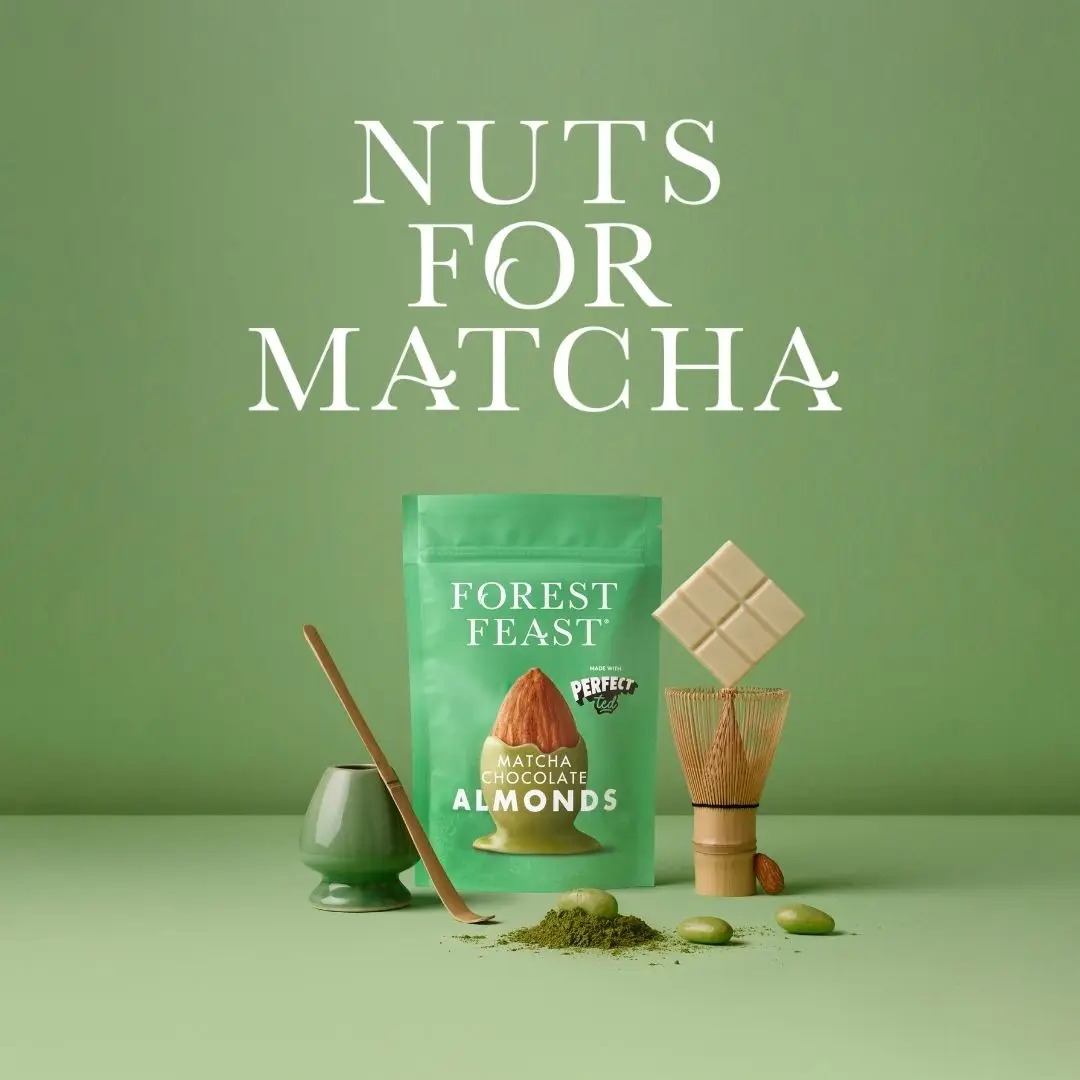 Forest Feast Matcha Chocolate Almonds product pouch displayed with a bamboo tea whisk and white chocolate